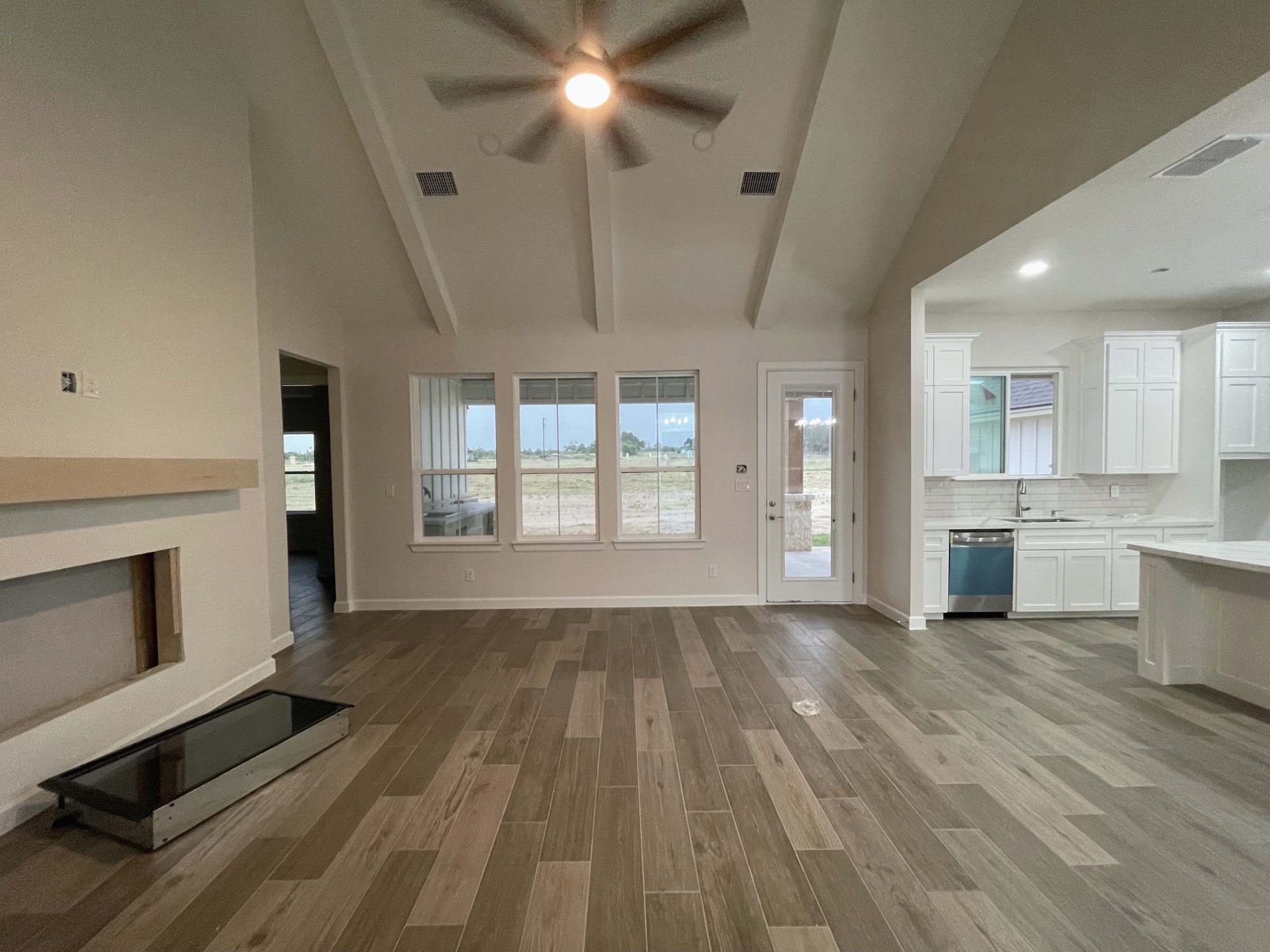 Open living room with vaulted ceiling and kitchen beyond